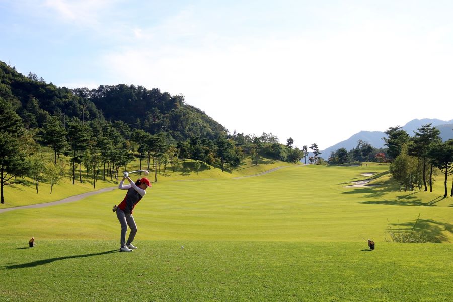 female golfer on tee box hiting with driver