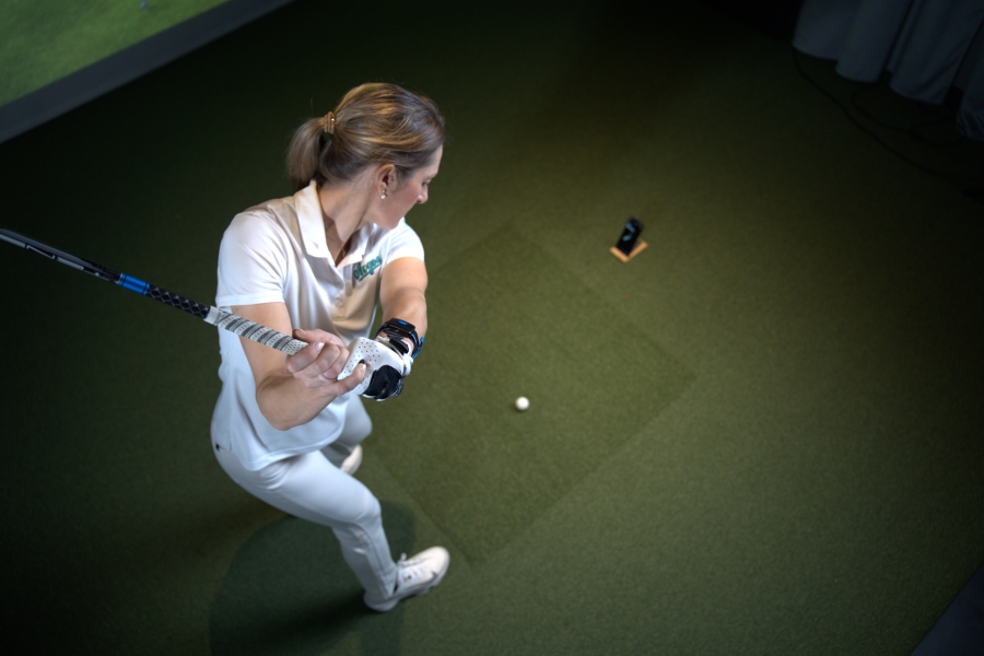 female golfer training indoor with HackMotion app