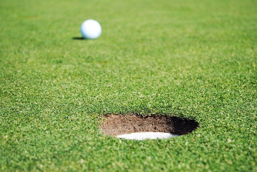 golf ball near to golf hole