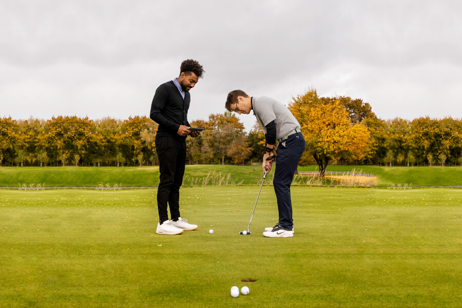 golf coach teaching golf player