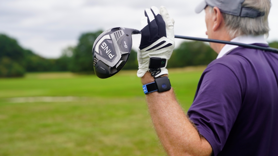 golfer holding driver and wearing hackmotion wrist sensor