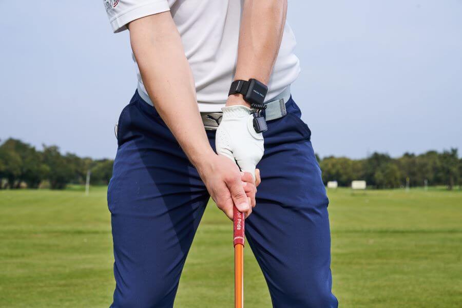 golfer holding golf club on closeup and wearing hackmotion sensor