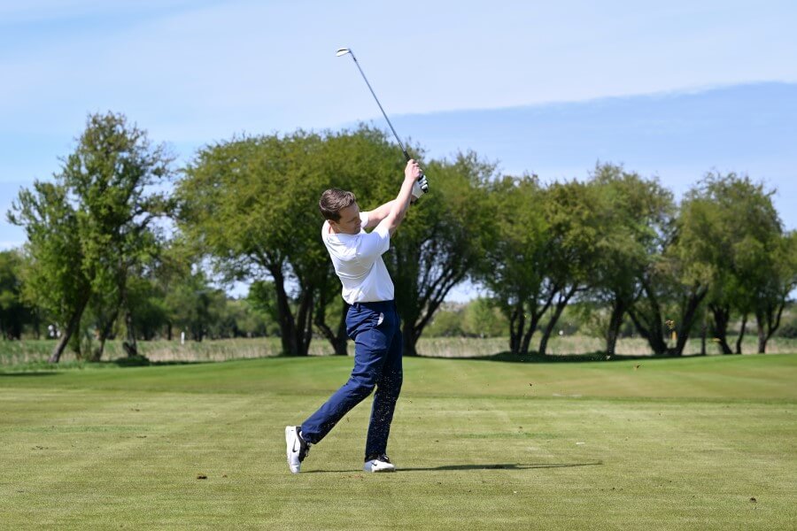 golfer on the course hitting iron golf club
