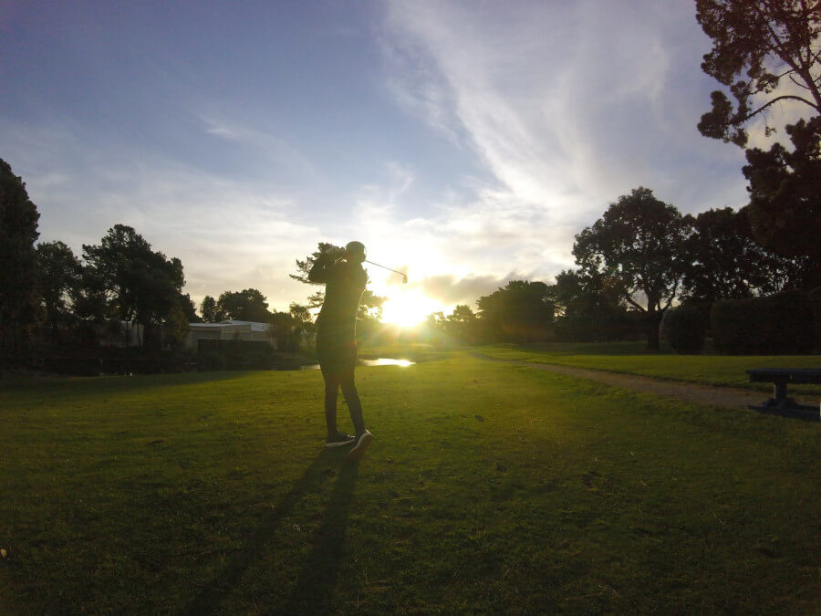 golfer standing on green grass field during game