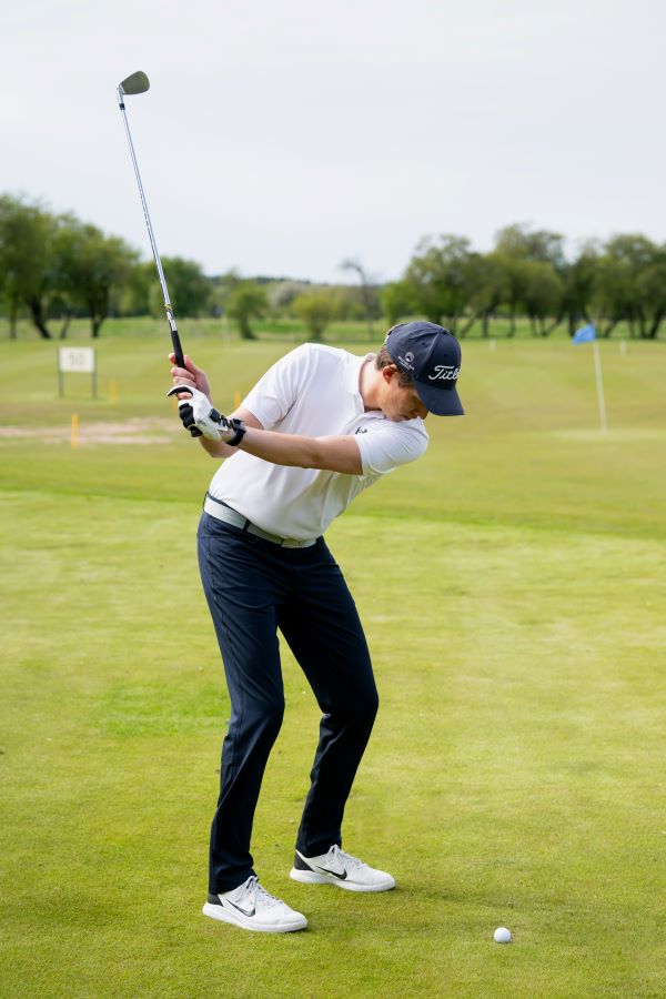 golfer training at the driving range with iron