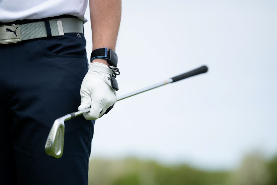 golfer wearing hackmotion wrist sensor and holding golf club