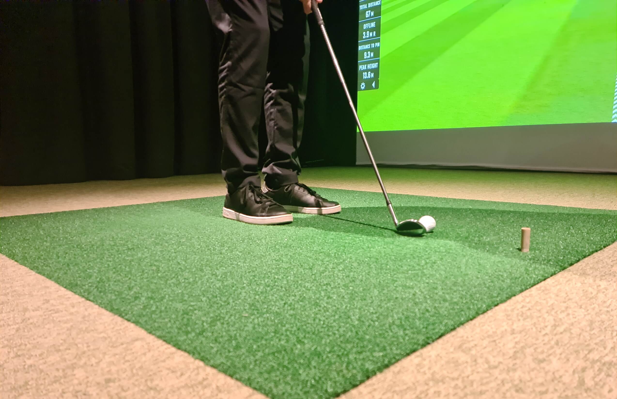 man is playing golf on golf simulator