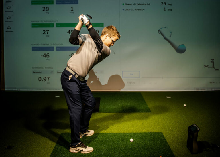 man playing golf using indoor golf monitor